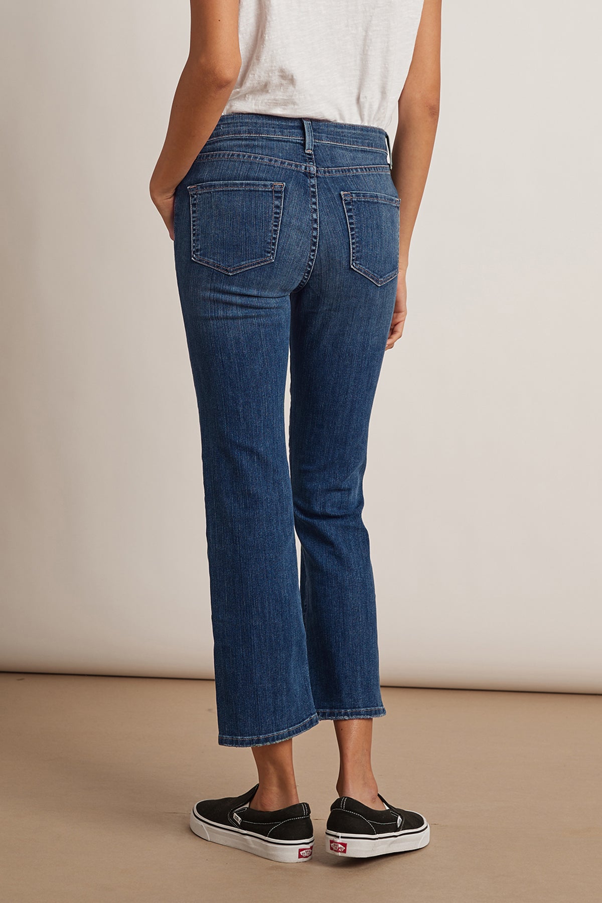   The view of a woman wearing a pair of Velvet by Graham & Spencer KATE HIGH RISE CROP JEAN showcases the denim fabric and waistline. 