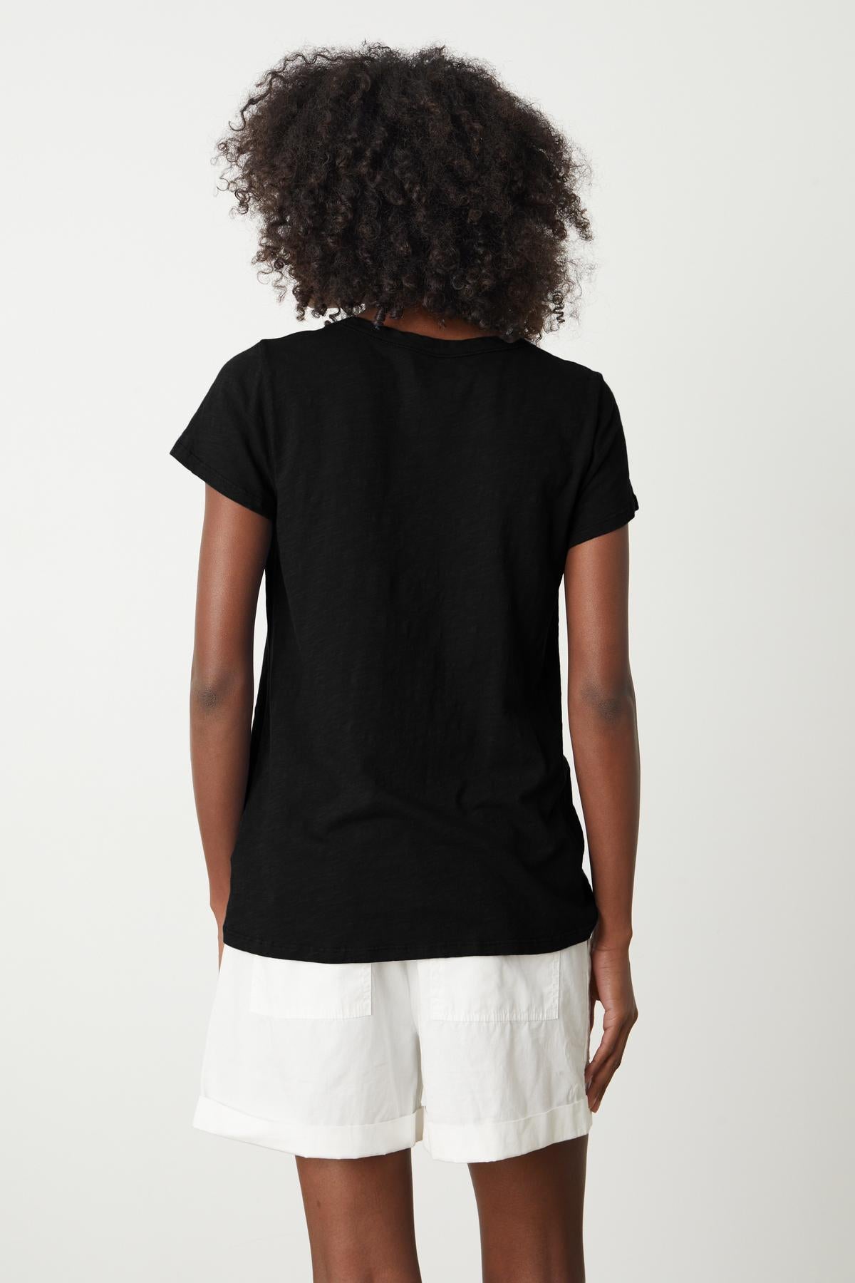 The back view of a woman wearing a Velvet by Graham & Spencer TILLY ORIGINAL SLUB CREW NECK TEE and shorts.-26235782103233