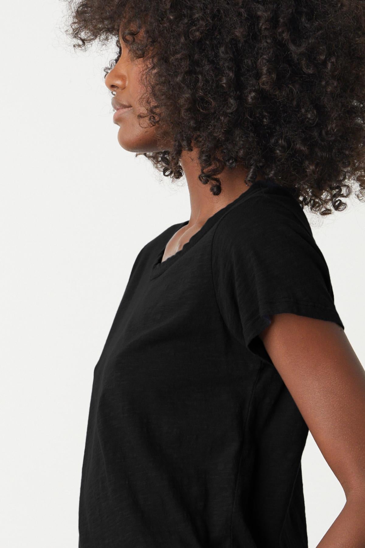   a woman wearing a black Velvet by Graham & Spencer TILLY ORIGINAL SLUB CREW NECK TEE with afro hair. 