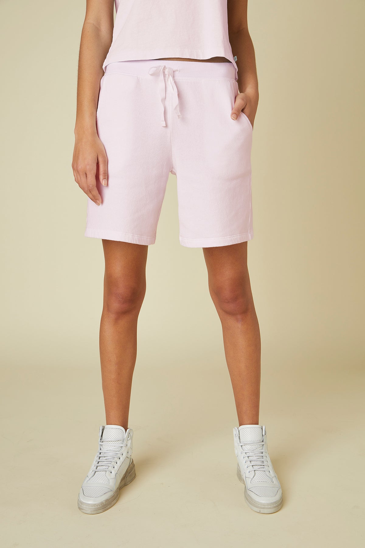 The model is wearing pink Velvet by Jenny Graham LAGUNA SWEATSHORT jogging shorts with an elastic waist and a white t-shirt.-24791114645697