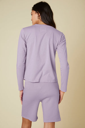 The back view of a woman wearing Velvet by Jenny Graham's LAGUNA SWEATSHORT with an elastic waist in an organic fleece pyjama set.