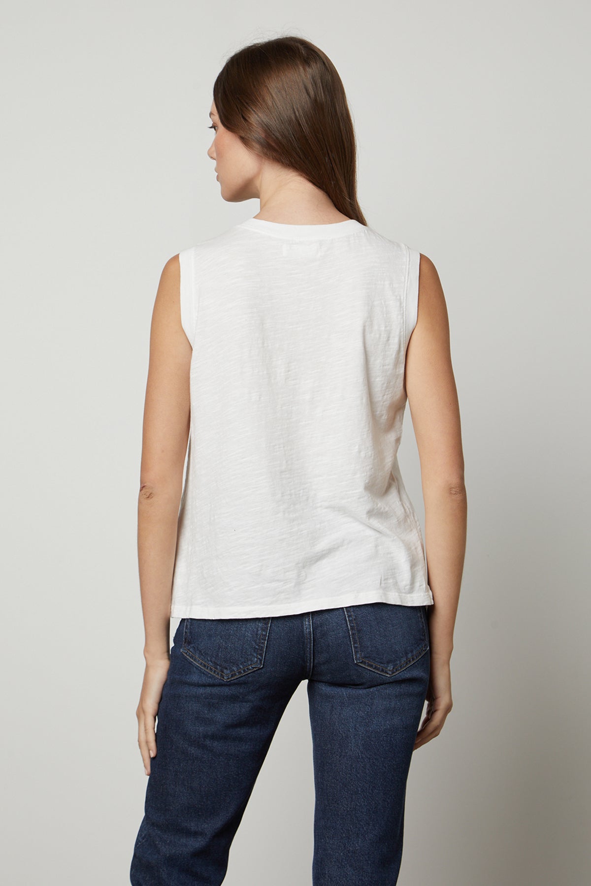 The back view of a woman wearing Velvet by Graham & Spencer's ELLEN VINTAGE SLUB TANK TOP and jeans.-26182429802689