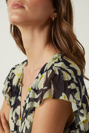 a woman wearing a Velvet by Graham & Spencer LUCIA PRINTED TOP with ruffled sleeves.