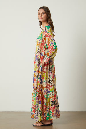 The model is wearing a SERENA PRINTED MAXI DRESS by Velvet by Graham & Spencer.