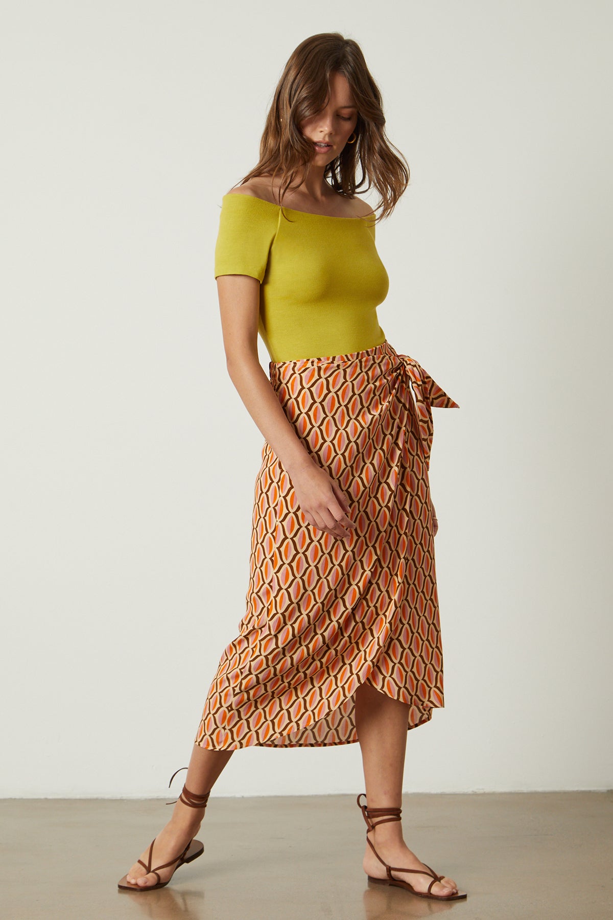   Eloise bodysuit in sundance yellow under Alisha skirt in orange geometric pattern and sandals full length front 