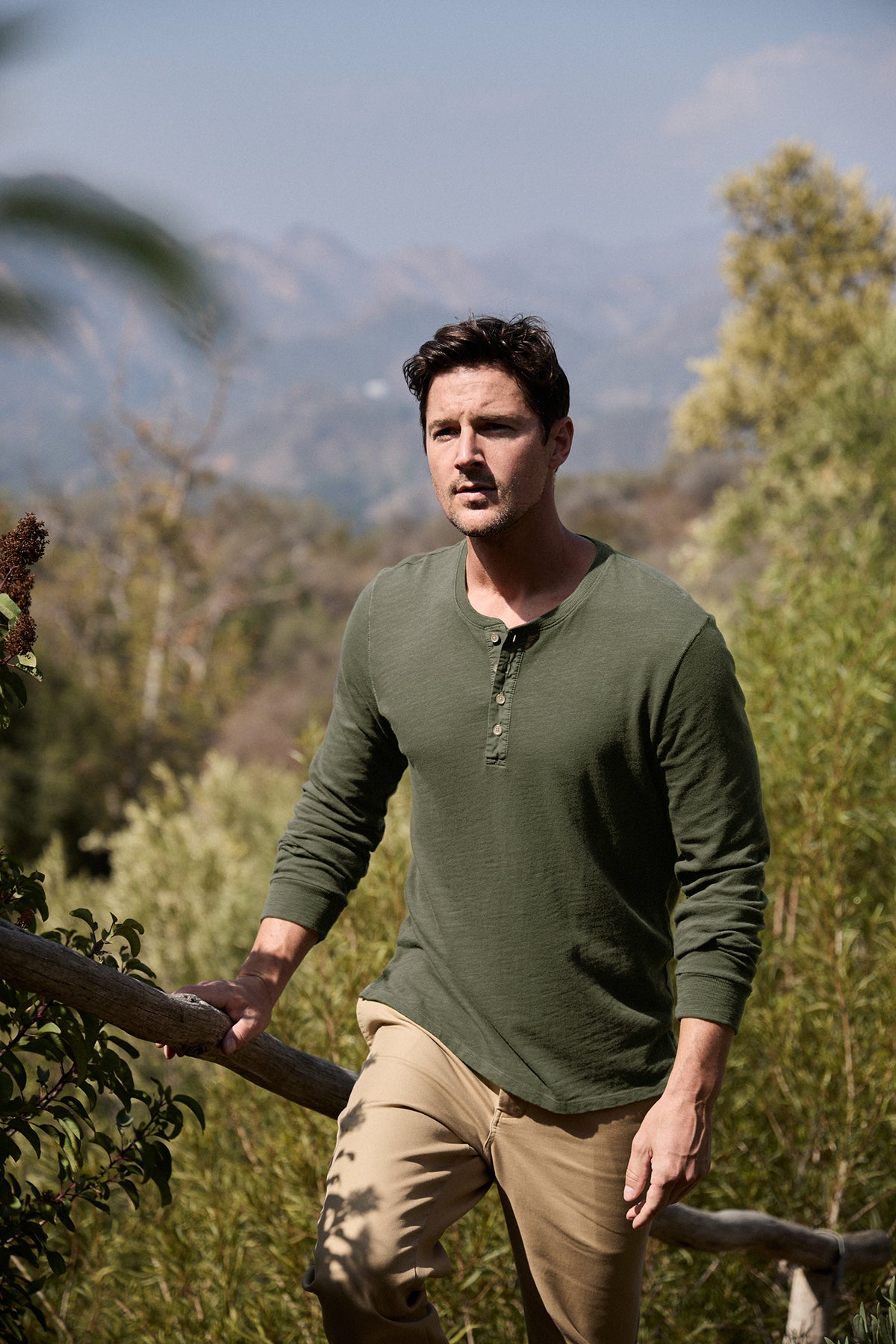 Model walking up steps outdoors wearing Gabe Henley in palm green with Aiden pant front-25854949982401