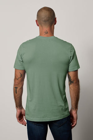 The back view of a man wearing a Velvet by Graham & Spencer HOWARD WHISPER CLASSIC CREW NECK TEE in a lightweight cotton knit for a vintage-feel softness.