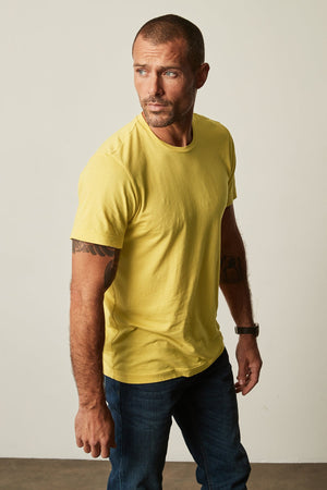 A man wearing a Velvet by Graham & Spencer HOWARD WHISPER CLASSIC CREW NECK TEE made of lightweight cotton knit.
