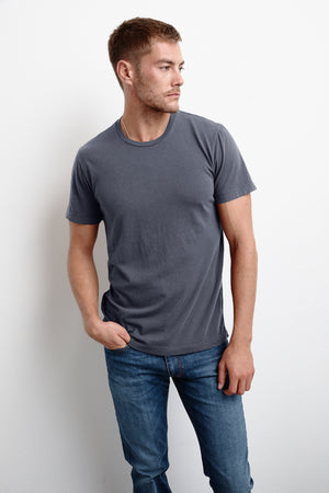 A man wearing jeans and a Velvet by Graham & Spencer HOWARD WHISPER CLASSIC CREW NECK TEE.