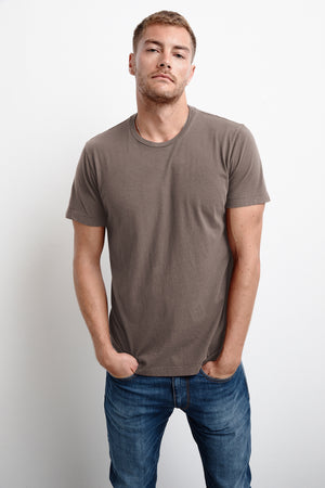 A man wearing a Velvet by Graham & Spencer Howard Whisper Classic Crew Neck Tee and jeans.