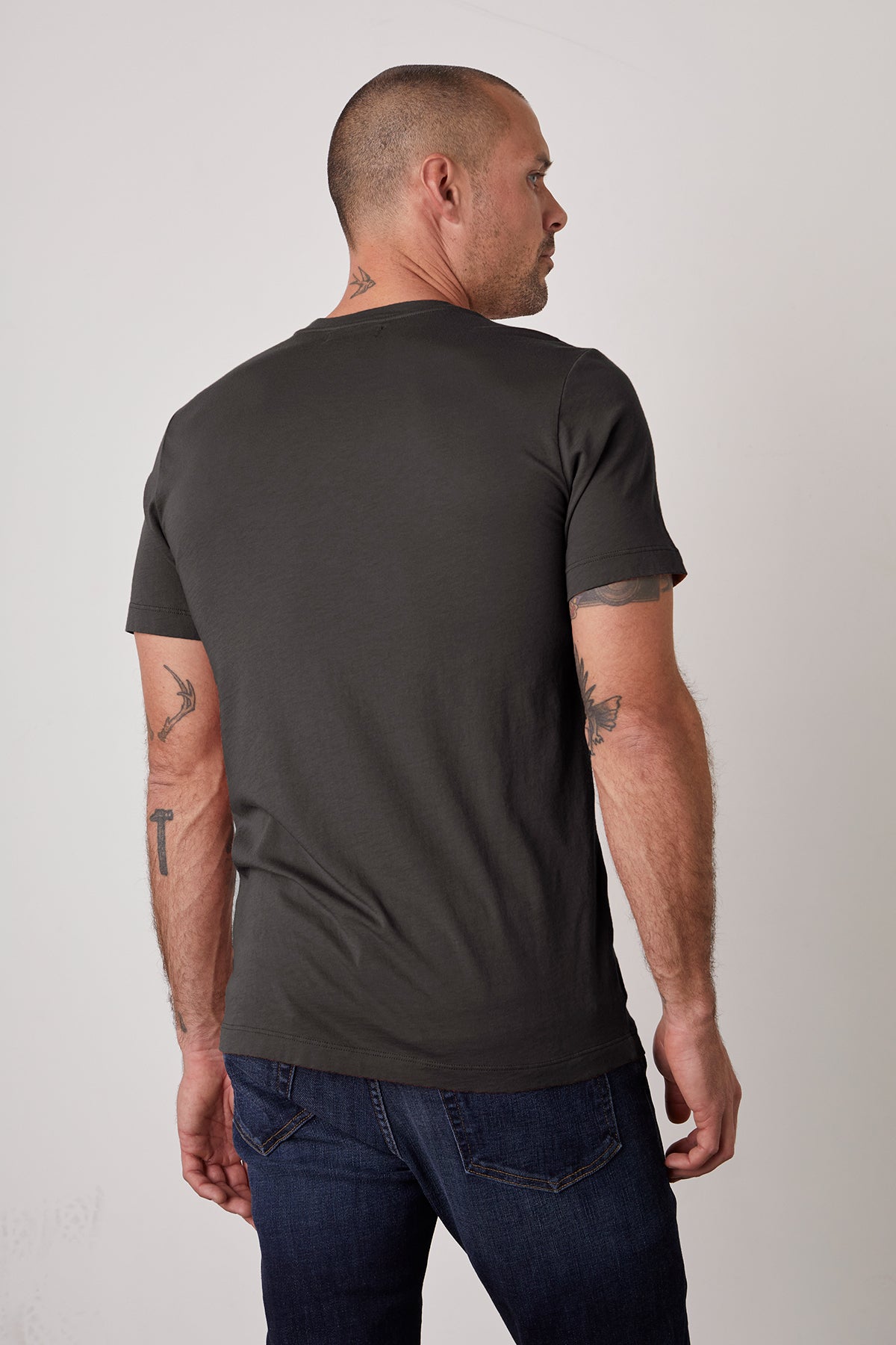   the back of a man wearing Velvet by Graham & Spencer SAMSEN WHISPER CLASSIC V-NECK TEE and jeans. 