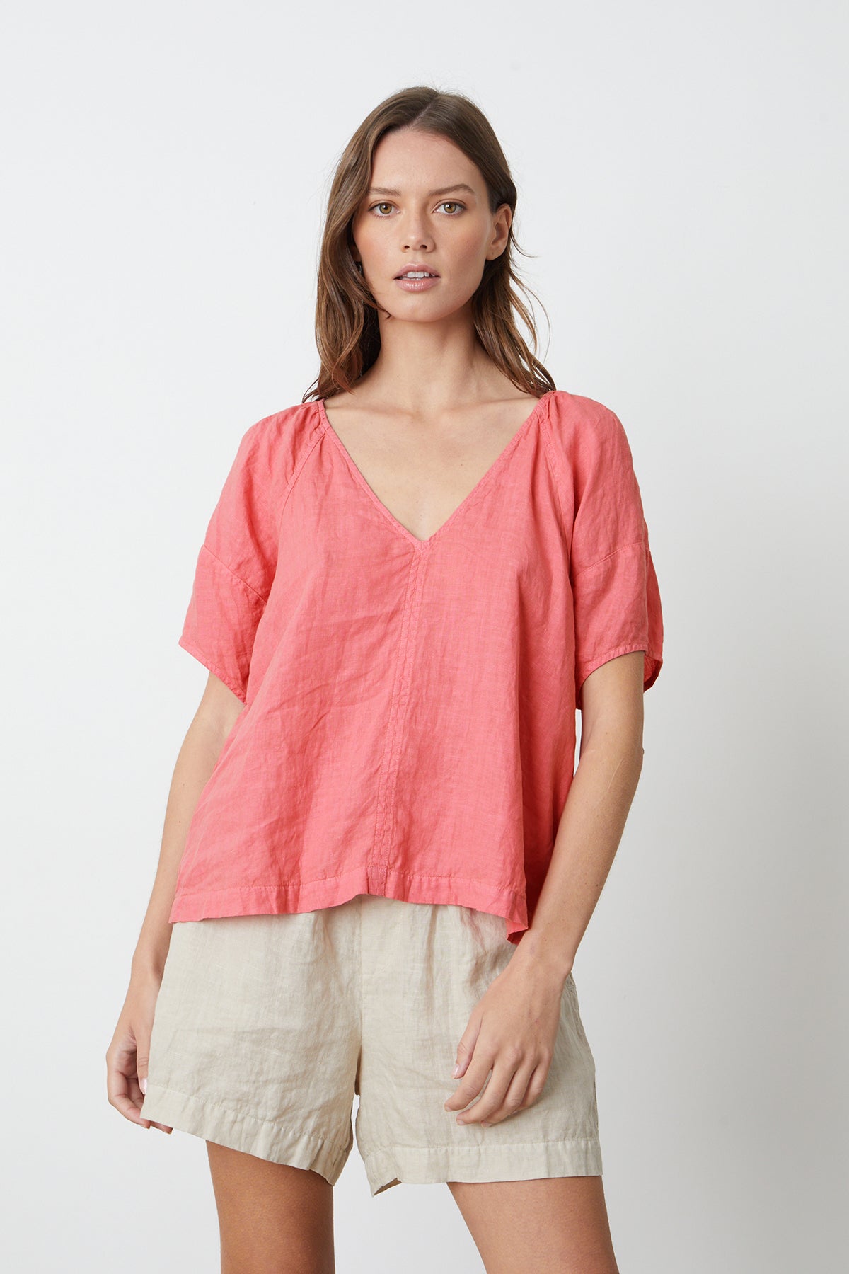 A woman wearing a Velvet by Graham & Spencer CALLIN PUFF SLEEVE LINEN TOP in rosebay and shorts front.-26262345547969