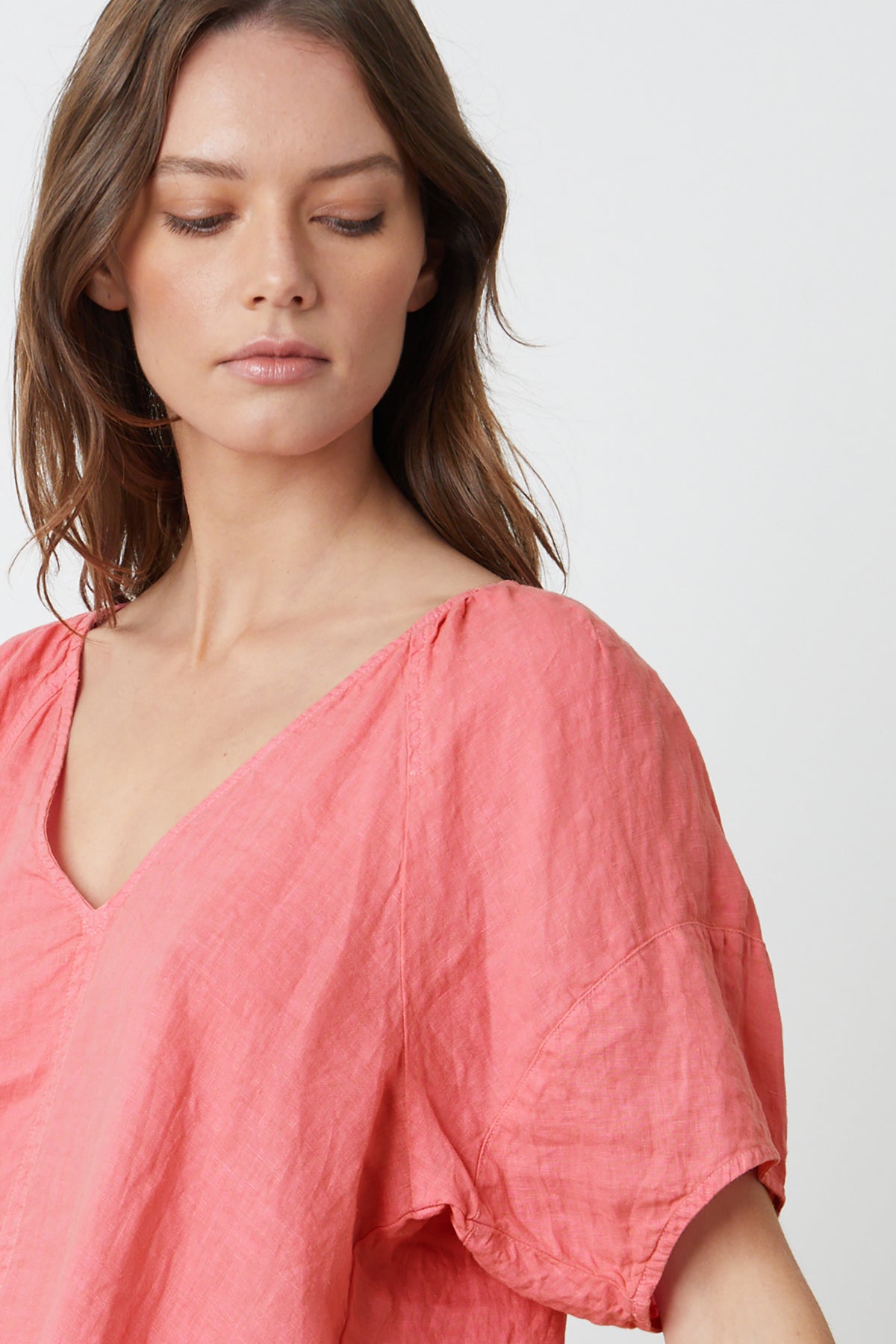   The model is wearing a Velvet by Graham & Spencer CALLIN PUFF SLEEVE LINEN TOP with a v-neck. 