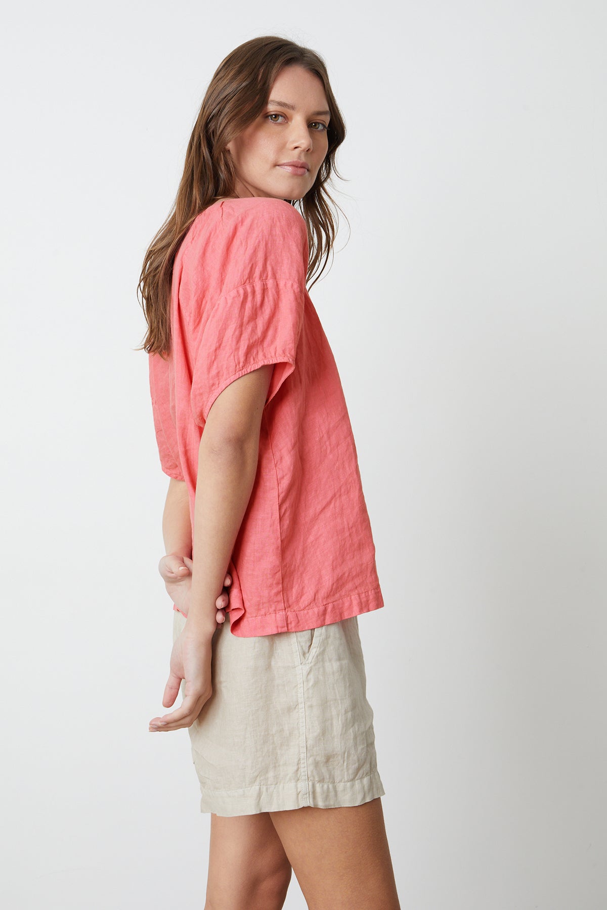   The model is wearing a Velvet by Graham & Spencer CALLIN PUFF SLEEVE LINEN TOP and sand colored Tammy shorts, side view. 