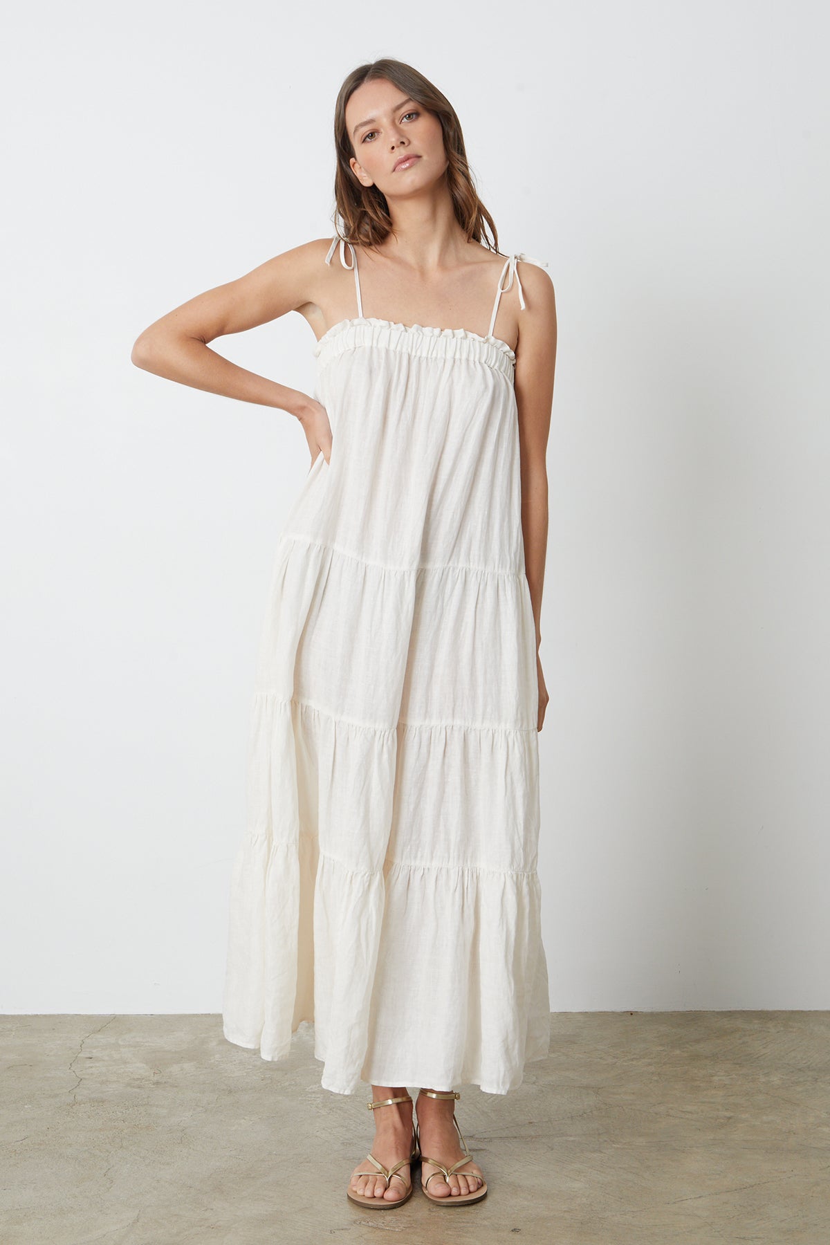 A model wearing a white Velvet by Graham & Spencer CHARLIE LINEN TIERED DRESS and sandals.-26296070504641