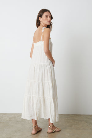 The back view of a woman wearing a Velvet by Graham & Spencer CHARLIE LINEN TIERED DRESS.