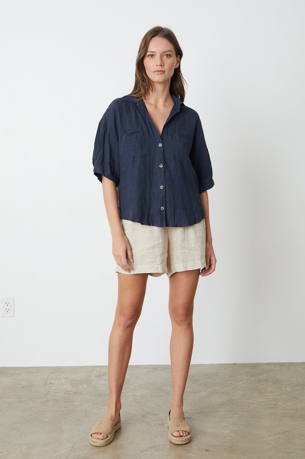 The model is wearing a MARIA LINEN BUTTON-UP SHIRT by Velvet by Graham & Spencer and tan shorts.-26262343319745