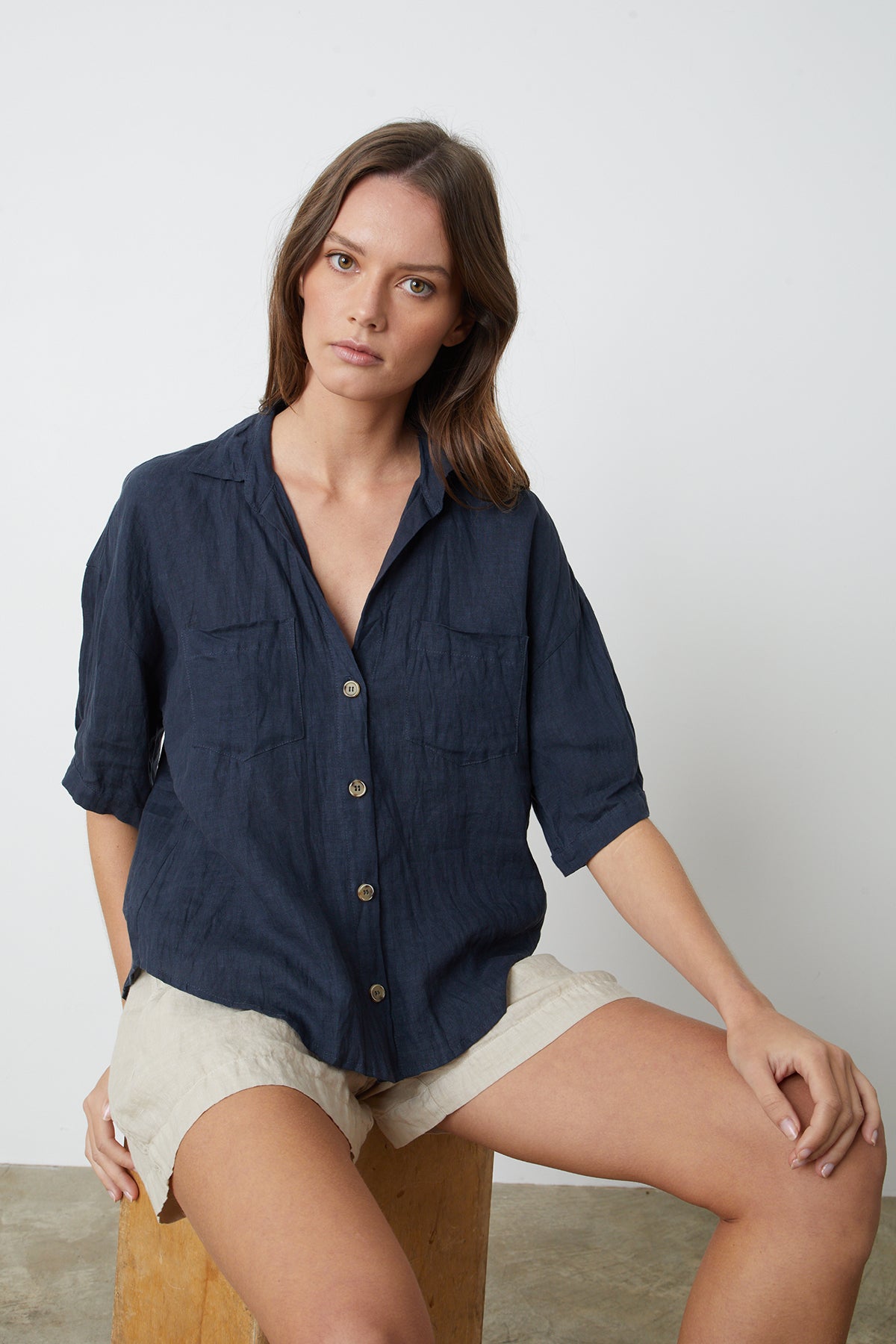   the model is wearing a Velvet by Graham & Spencer MARIA LINEN BUTTON-UP SHIRT and tan shorts. 