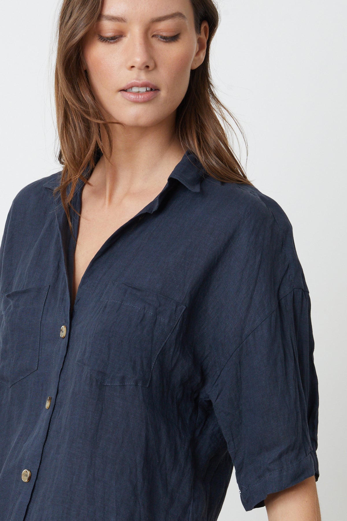   The model is wearing a blue Maria Linen Button-Up Shirt by Velvet by Graham & Spencer. 