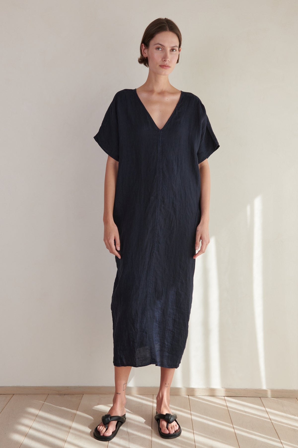 a model wearing a navy Velvet by Jenny Graham linen MONTANA DRESS and flip flops.-26293194621121