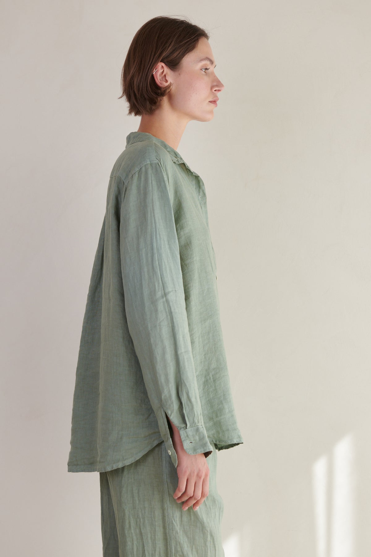 a woman wearing a Green Linen MULHOLLAND SHIRT by Velvet by Jenny Graham and pants.-26293074657473