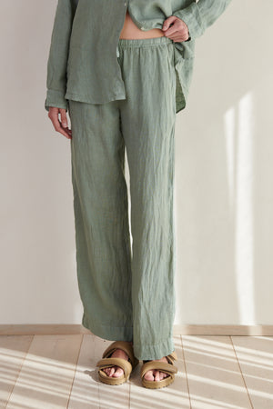 A woman wearing green Velvet by Jenny Graham PICO pants and sandals.