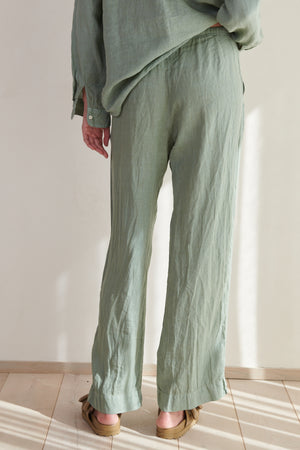 The back view of a woman wearing Velvet by Jenny Graham's PICO PANT in green linen.