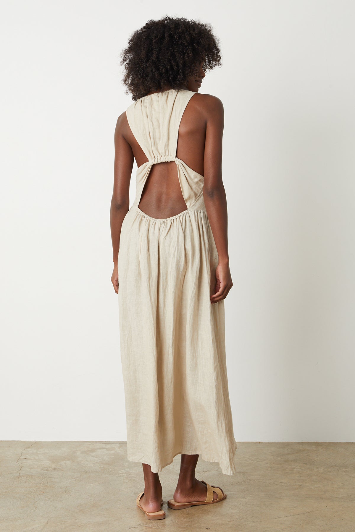 the back view of a woman wearing the Velvet by Graham & Spencer POLLY LINEN CUT OUT DRESS.-26296354799809