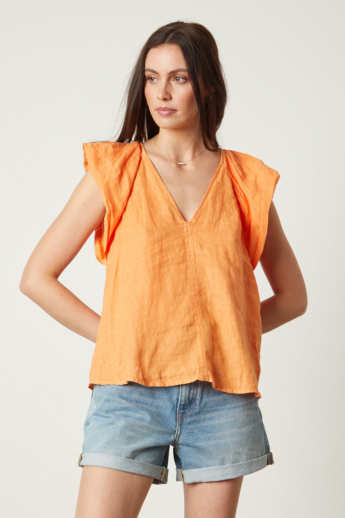   Ava Linen V-Neck Top in orange heat color with blue denim shorts, necklace 
