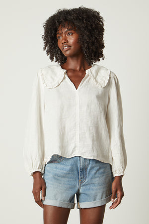 Sofia linen top in beach with blue denim shorts front