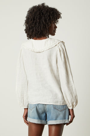 Sofia linen top in beach with blue denim shorts back