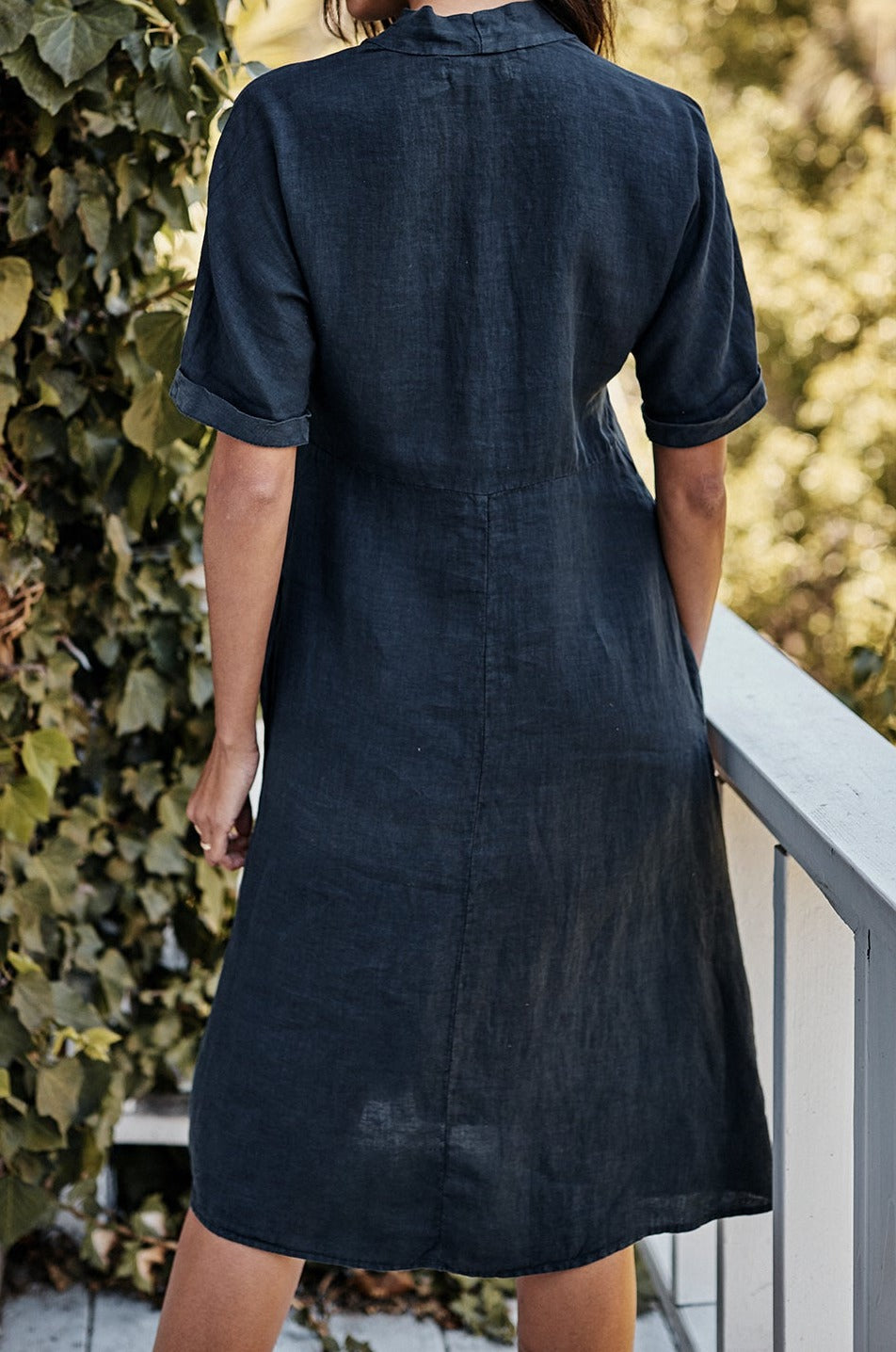 The back view of a woman wearing a Velvet by Graham & Spencer WINLEY LINEN DRESS.-21830709018817