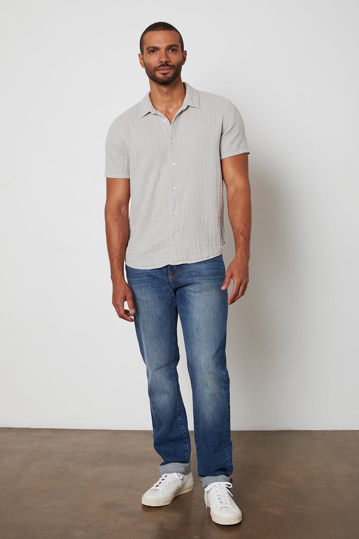   Cotton gauze Christian button up shirt in light grey and blue jeans. 