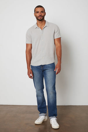 Cotton gauze Christian button up shirt in light grey and blue jeans.