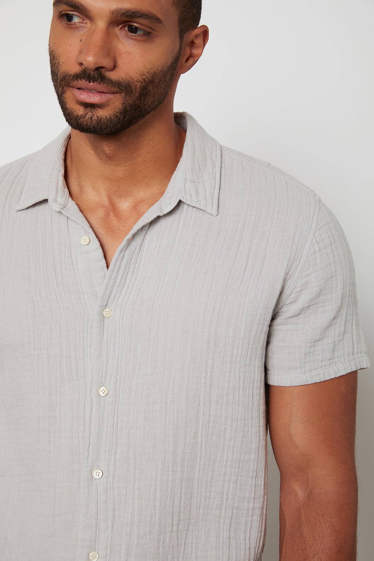   Front detail of Christian button up cotton gauze shirt in light grey. 