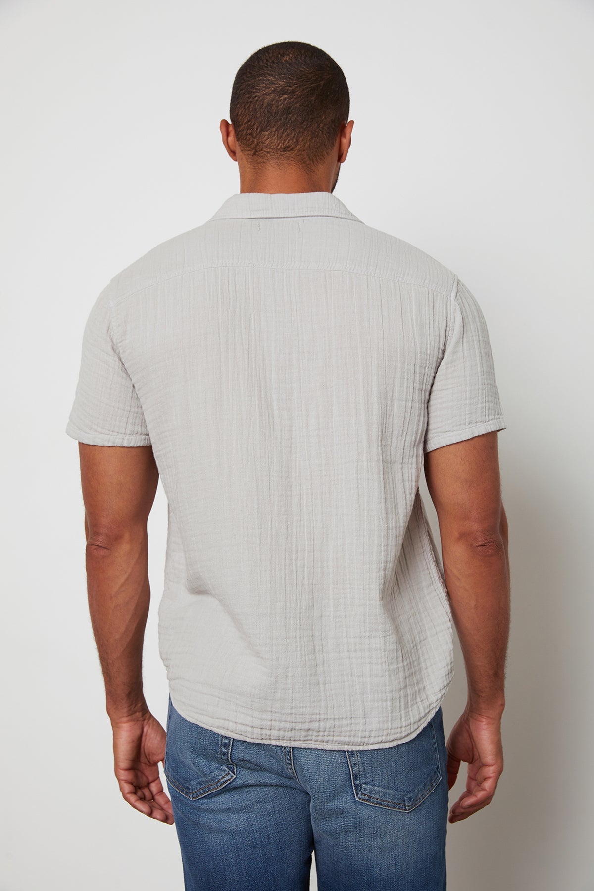   Back of Christian button up cotton gauze shirt in light grey. 
