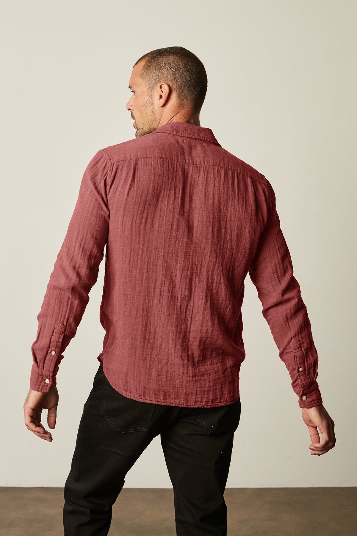   The back of a man wearing a Velvet by Graham & Spencer ELTON button-up shirt with a natural texture. 