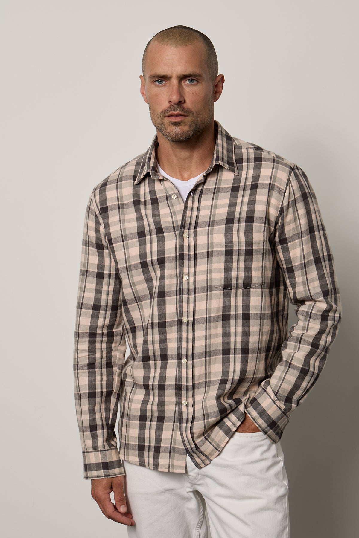 a man wearing a LEONARD PLAID BUTTON-UP SHIRT by Velvet by Graham & Spencer and white pants.-26079099650241